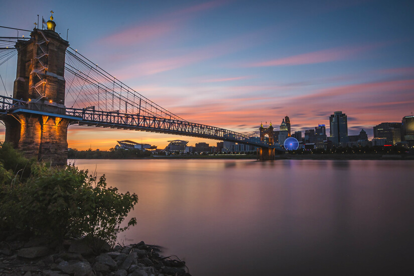 Bridge Over River In City Against Sky During Sunset